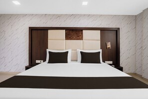 Una habitación de hotel moderna con una cama grande, un cabecero de madera y una pared con diseño de mármol.