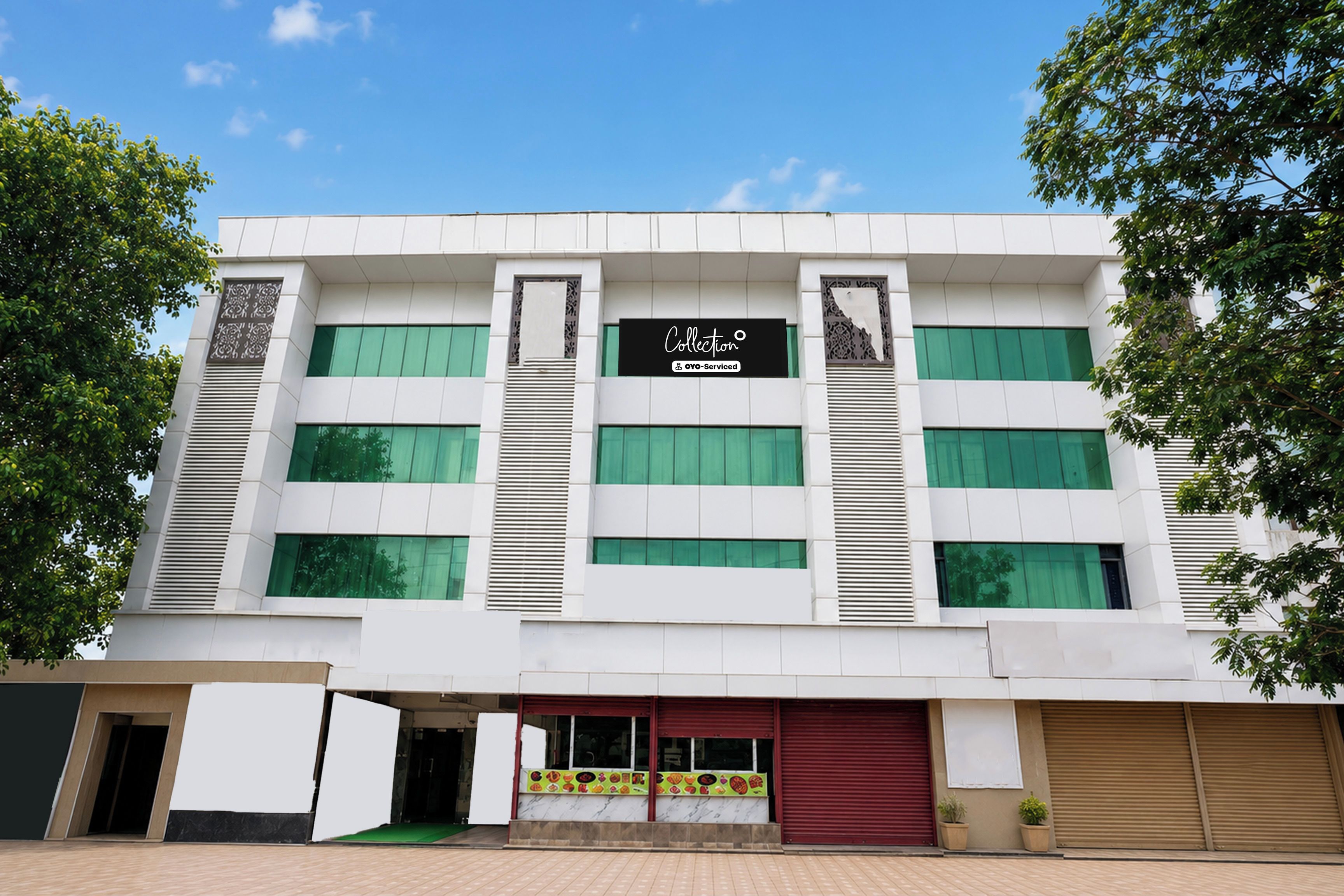 Un edificio moderno con un letrero que dice 'Collection' y 'OYO-Serviced'.