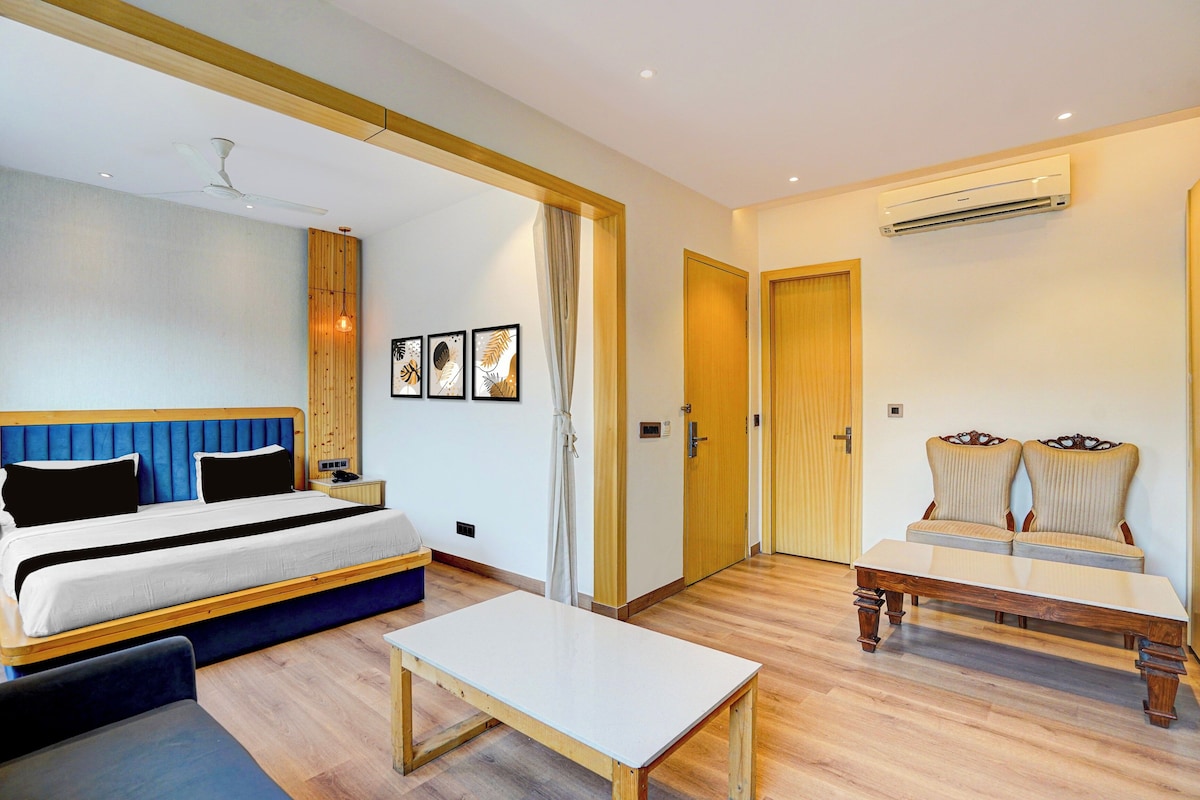 Quarto de hotel com cama, escrivaninha, cadeira e ar condicionado.