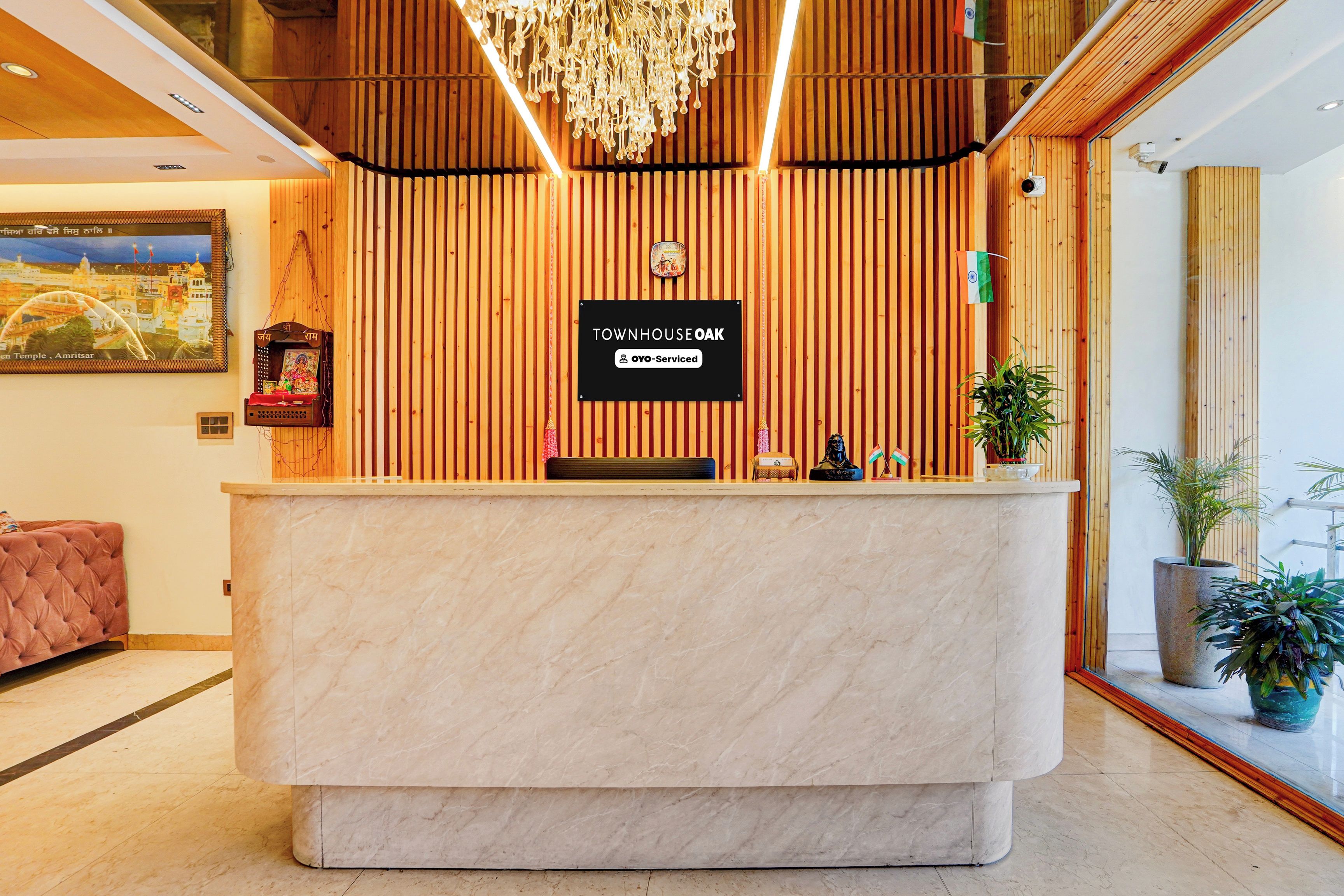 Una mesa de recepción con un letrero que dice 'TOWNHOUSE OAK' y un logotipo de 'OYO-Serviced'.