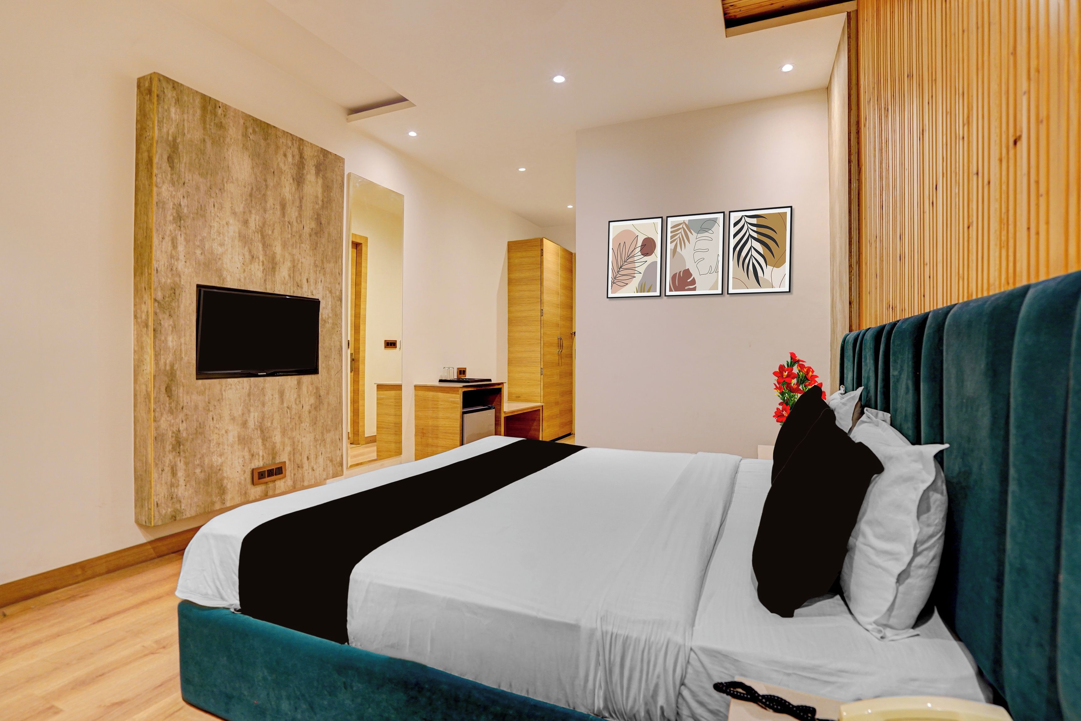 Une chambre d’hôtel équipée d’un lit, d’un téléviseur fixé au mur, d’un bureau et d’une petite kitchenette.