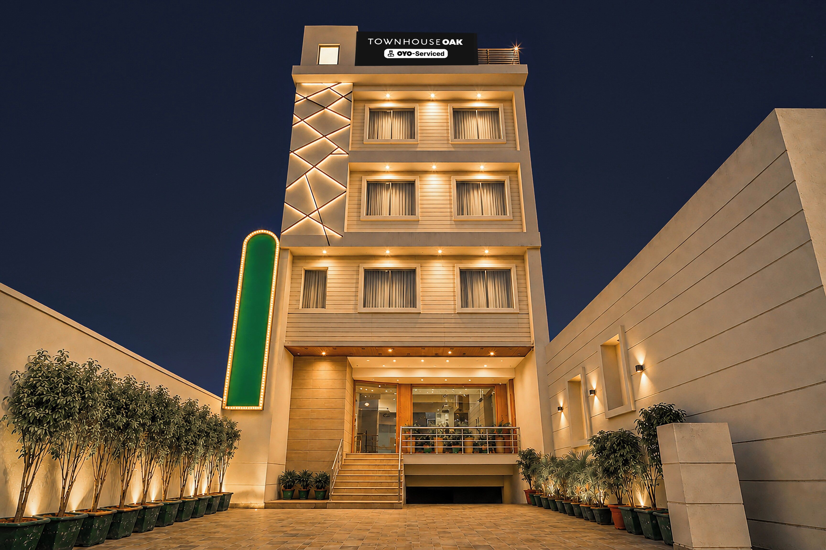 A multi-story hotel with a sign indicating 'Townhouse Oak' and 'Oyo-Serviced' on the top.