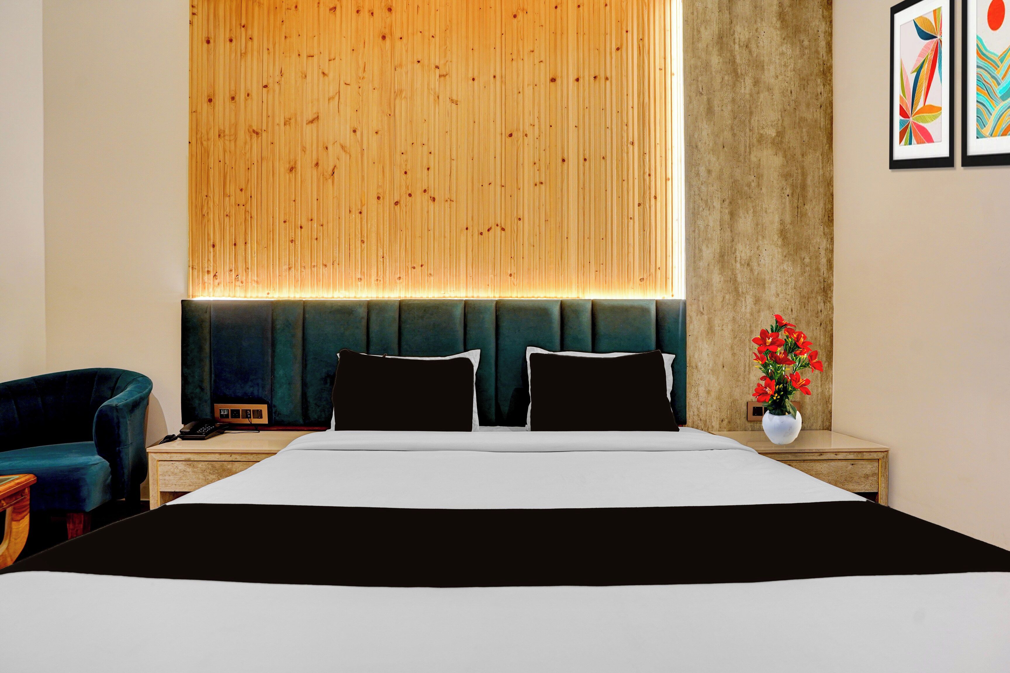 Ein Hotelzimmer mit einem großen Bett, zwei Nachttischen, einem Sessel und einem hölzernen Kopfteil.