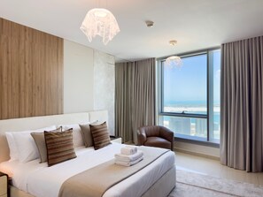 A modern hotel room with a large bed, a view of the city, and a cityscape visible through the window. - Vanilla Homes Luxury 2BR in Reem Island (Abu Dhabi)
