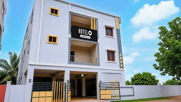 A multi-story hotel with a sign indicating it is serviced by OYO.
