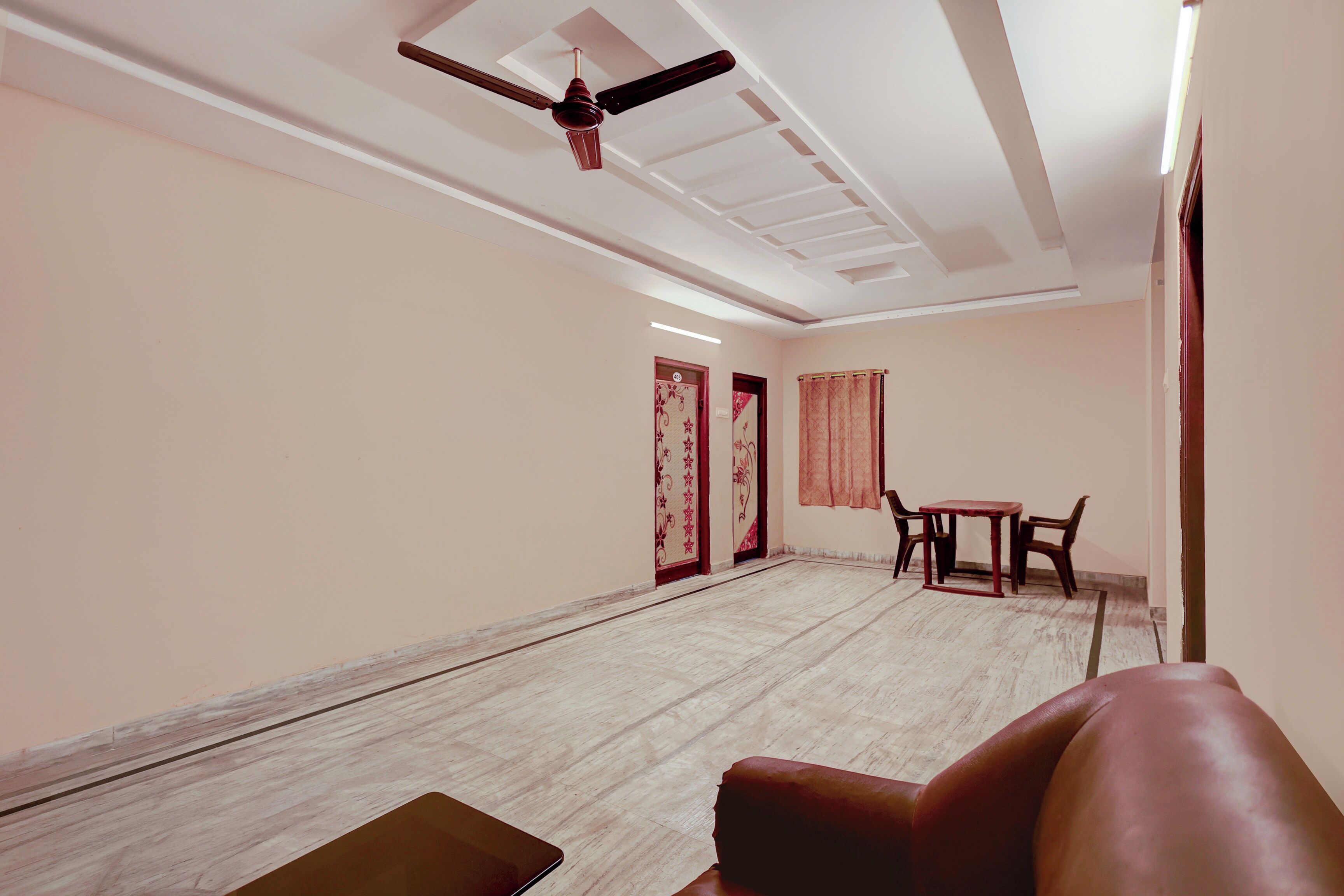Une pièce dotée d’un ventilateur de plafond, d’une table avec des chaises et d’une porte ornée d’un panneau décoratif.
