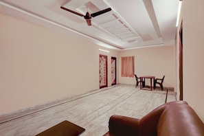 Una habitació amb ventilador de sostre, una taula i cadires, i una porta amb un panell decoratiu.