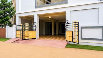 A modern two-story building with a central entrance, a balcony on the upper floor, and a checkered floor pattern inside.