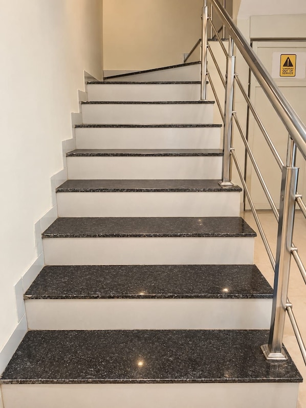 A staircase with a metal handrail and a warning sign indicating temporary out of service. - Silvotel SmartBy Bizzgrow Hotels (Indore)