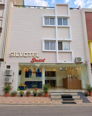 A hotel named 'Silvotel Smart' with a modern facade, large windows, and a reception area with a blue sofa and artwork. - Silvotel SmartBy Bizzgrow Hotels (Indore)