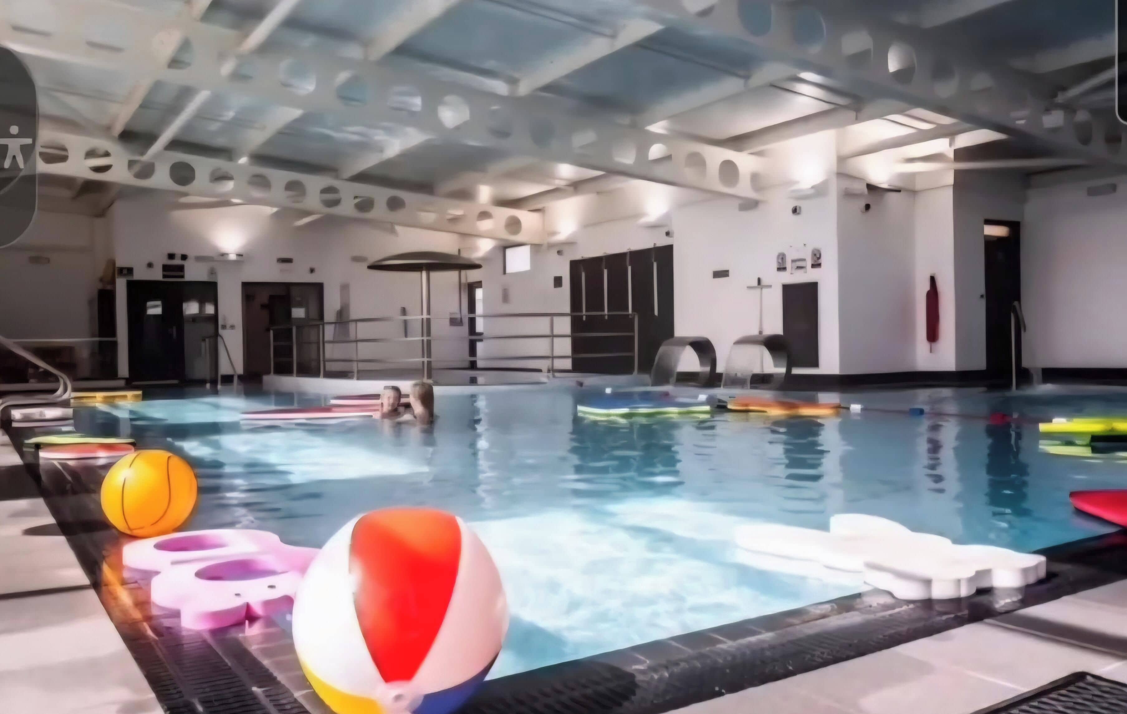 An indoor swimming pool with lanes, starting blocks, and safety equipment.