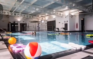 Piscina interna com pistas demarcadas, blocos de partida e equipamentos de segurança.