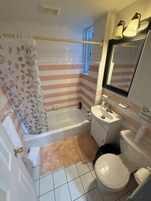 A bathroom with a bathtub, a sink, and a toilet. - Room Steps Métro & Downtown MTL (Montréal)