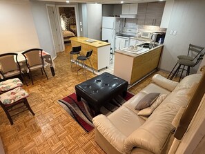 A compact living space with a kitchenette, a dining area, and a sofa. - Room Steps Métro & Downtown MTL (Montréal)