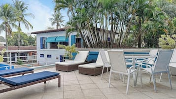 A rooftop pool area with lounge chairs and a small pool.
