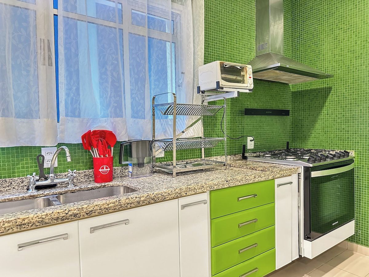 A kitchen with a gas stove, oven, and a microwave on the countertop.