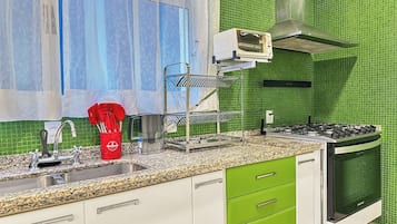 A kitchen with a gas stove, oven, and a microwave on the countertop.