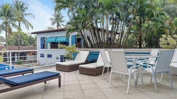 A rooftop pool area with lounge chairs and a small pool.