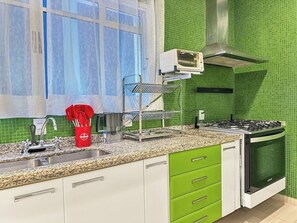 Une cuisine équipée d’une cuisinière à gaz, d’un four et d’un four à micro-ondes posé sur le plan de travail.