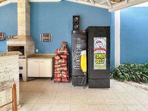 Una cocina comercial con un horno de piedra, dispensador de cerveza y un cartel publicitario de cerveza.