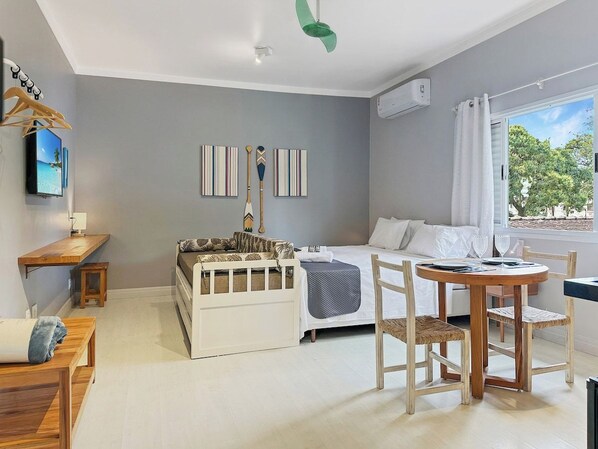 A bedroom with a bed, bedside table, and a window with curtains.