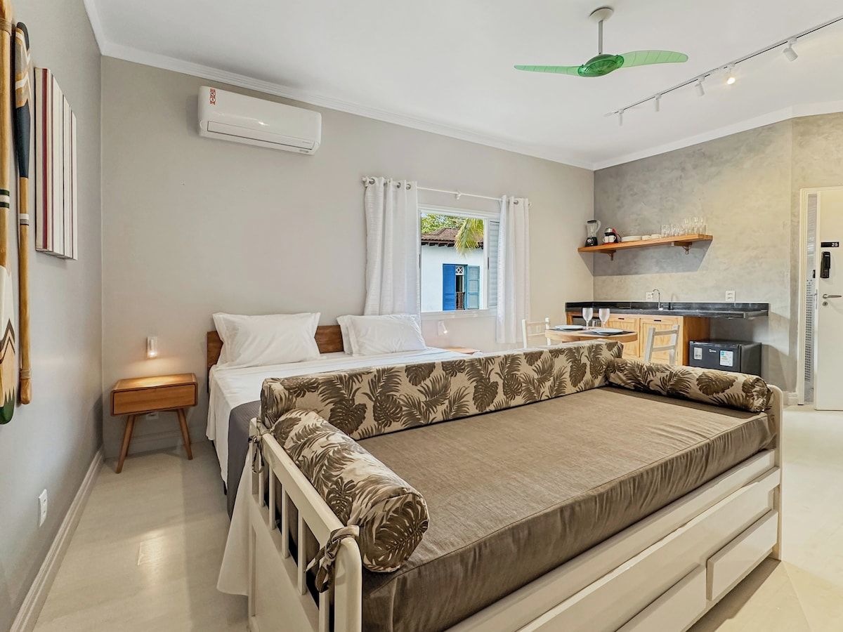 A bedroom with a bed, bedside table, and a window with curtains.