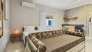 A bedroom with a bed, bedside table, and a window with curtains.
