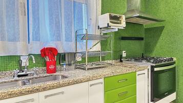 Una cocina con estufa a gas, horno y microondas sobre la encimera.