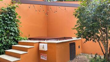 A spa area with a hot tub, steps leading up to it, and a sign indicating no smoking.