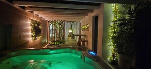 Ein Wellnessbereich mit Whirlpool, Holzwänden und Zierpflanzen.