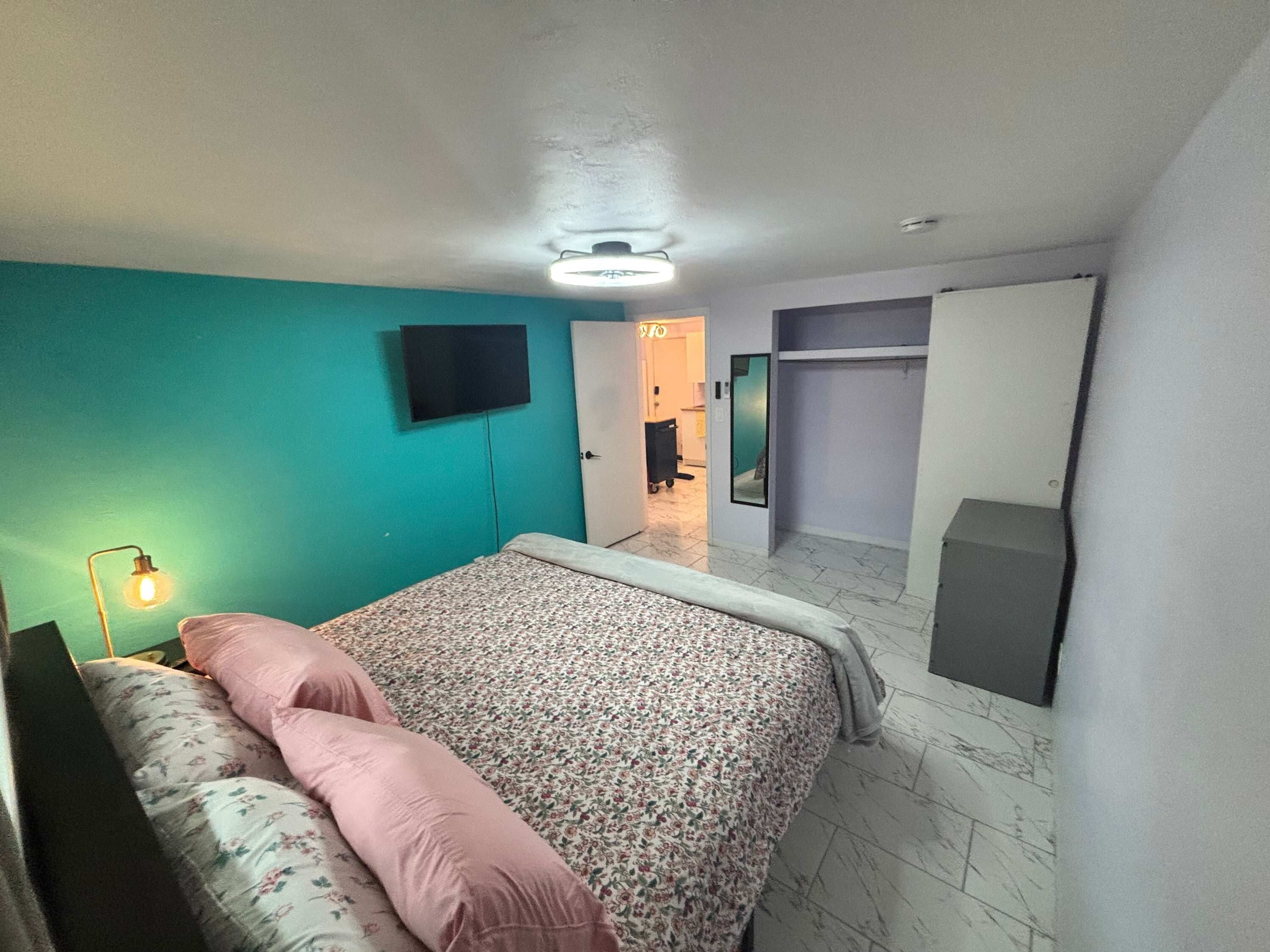 A bedroom with a bed, a television, and a wardrobe.