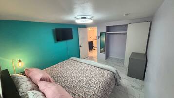 A bedroom with a bed, a television, and a wardrobe.