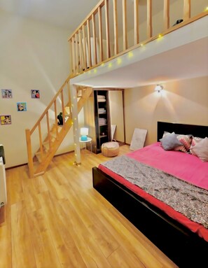 A bedroom with a bunk bed, wooden flooring, a staircase, and a bedside table with a lamp. - Seidabadi features a open-plan duplex bedroom, a comfortable living room sofa. (T'bilisi)