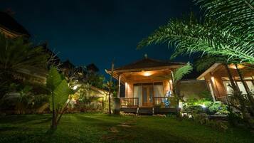 A house with a porch, surrounded by greenery.