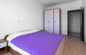 A bedroom with a bed, a wardrobe, a nightstand, and a door leading to another room. - Amazing apartment in Crikvenica with WiFi (Crikvenica)