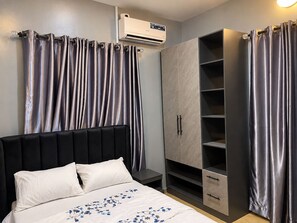 A bedroom with a bed, a wardrobe, and curtains. - Serene 2-Bed-Apt ~ 24hrs Pwr ~ Unlimited Internet (Lagos)
