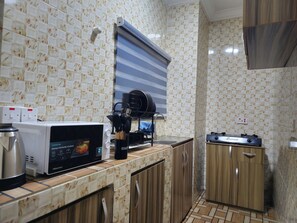 A kitchen with a microwave, a coffee maker, and a stove. - Serene 2-Bed-Apt ~ 24hrs Pwr ~ Unlimited Internet (Lagos)