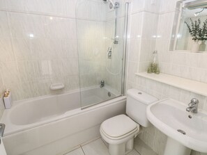 A bathroom with a glass-enclosed shower, a toilet, and a sink. - Hafan y Tyddyn (Newport)