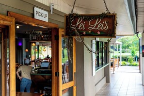 A restaurant entrance with a 'PICK UP' sign and a hanging 'Lei Lei's' sign. - Turtle Bay 1 Bedroom w/AC & Lanai (Kahuku)
