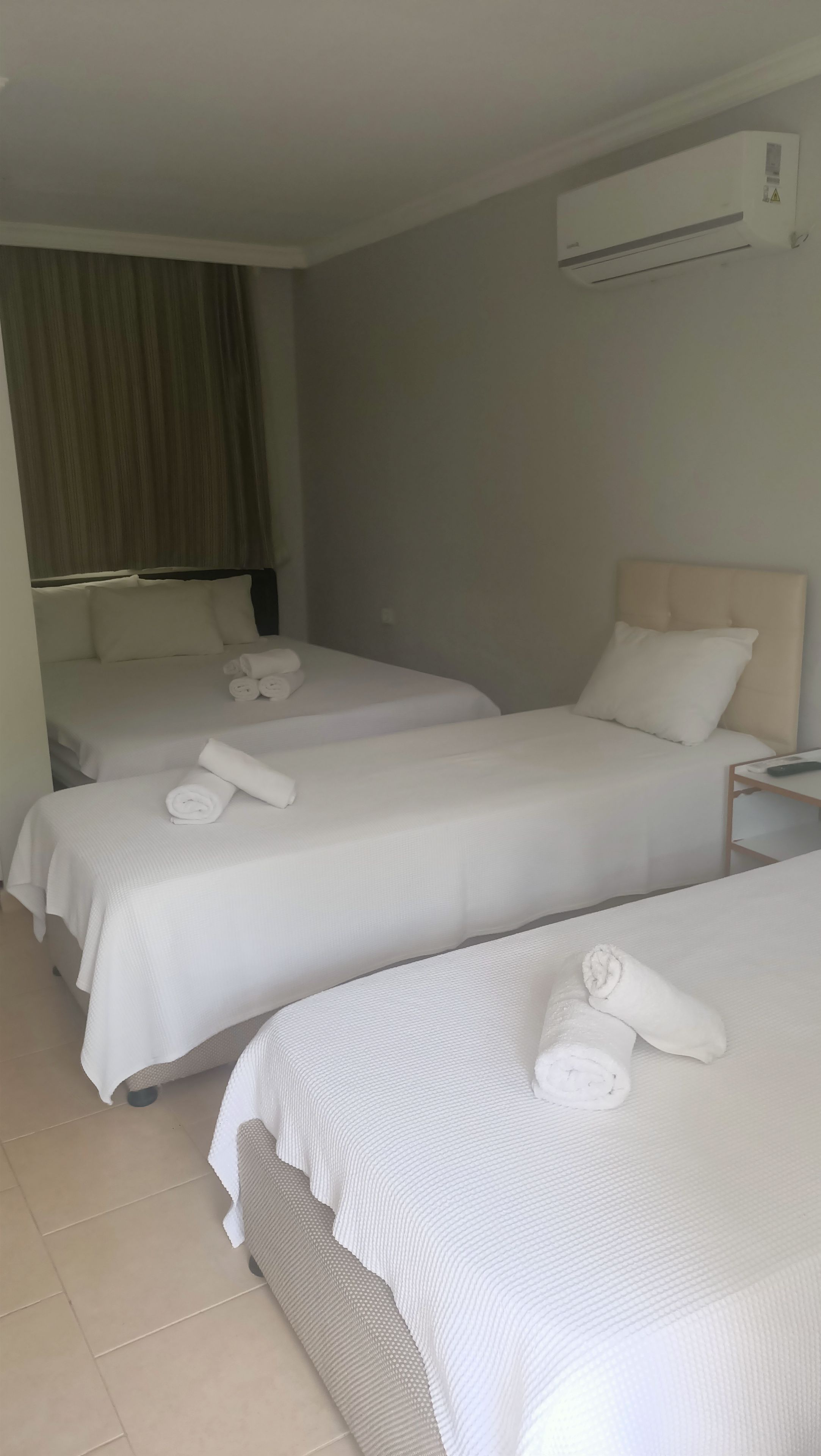 Een hotelkamer met twee bedden, elk voorzien van netjes gevouwen handdoeken en een hoofdeinde.