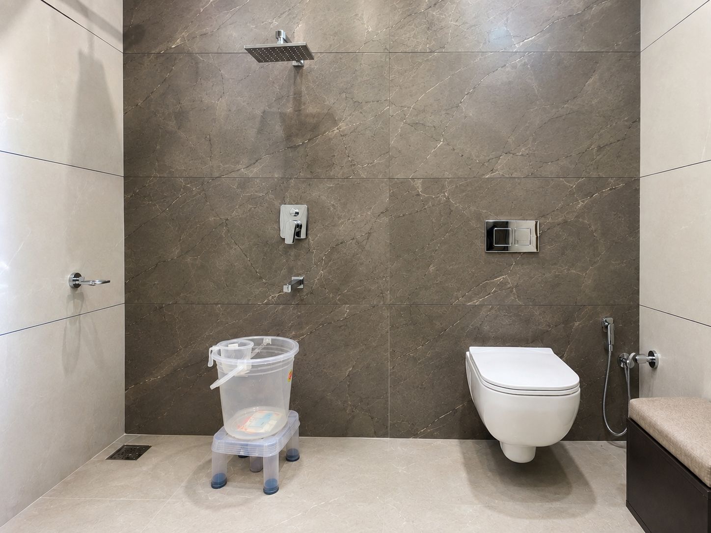 A modern bathroom with a shower, toilet, and a water dispenser.