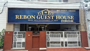 Une enseigne pour la maison d’hôtes Rebon, avec un numéro de téléphone et un logo indiquant qu’elle est enregistrée auprès du gouvernement indien.