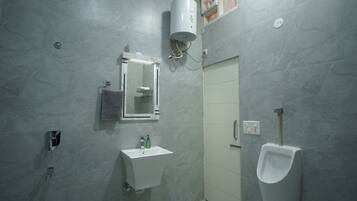 A bathroom with a sink, mirror, towel rack, urinal, and a shower area.