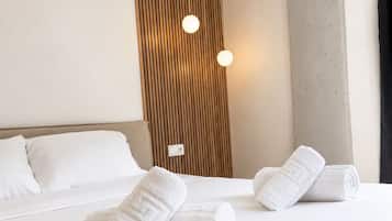 Habitación de hotel con cama, almohadas, un panel decorativo de madera y una lámpara.