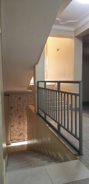 Una escalera con baranda de metal que sube a un piso superior.