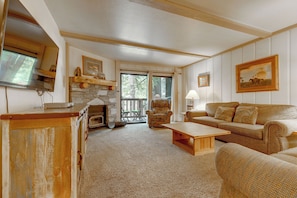 A cozy living room with a fireplace, a sofa, a coffee table, and a television. - Steps to Slopes! Mammoth Mountain Condo (Mammoth Lakes)