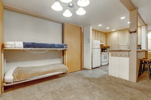A compact room with bunk beds, a kitchenette, and a bathroom. - Steps to Slopes! Mammoth Mountain Condo (Mammoth Lakes)