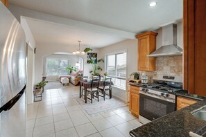 A modern kitchen with a built-in oven, a dining area with a table and chairs, and a living space with a sofa and a coffee table. - Seaside Monthly Rental Across From Martin Park (Seaside)