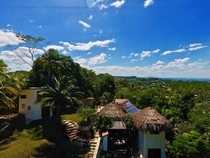 A rural landscape with thatched-roof huts, lush greenery, and a clear sky. - witzob glamping adventures (San Ignacio)