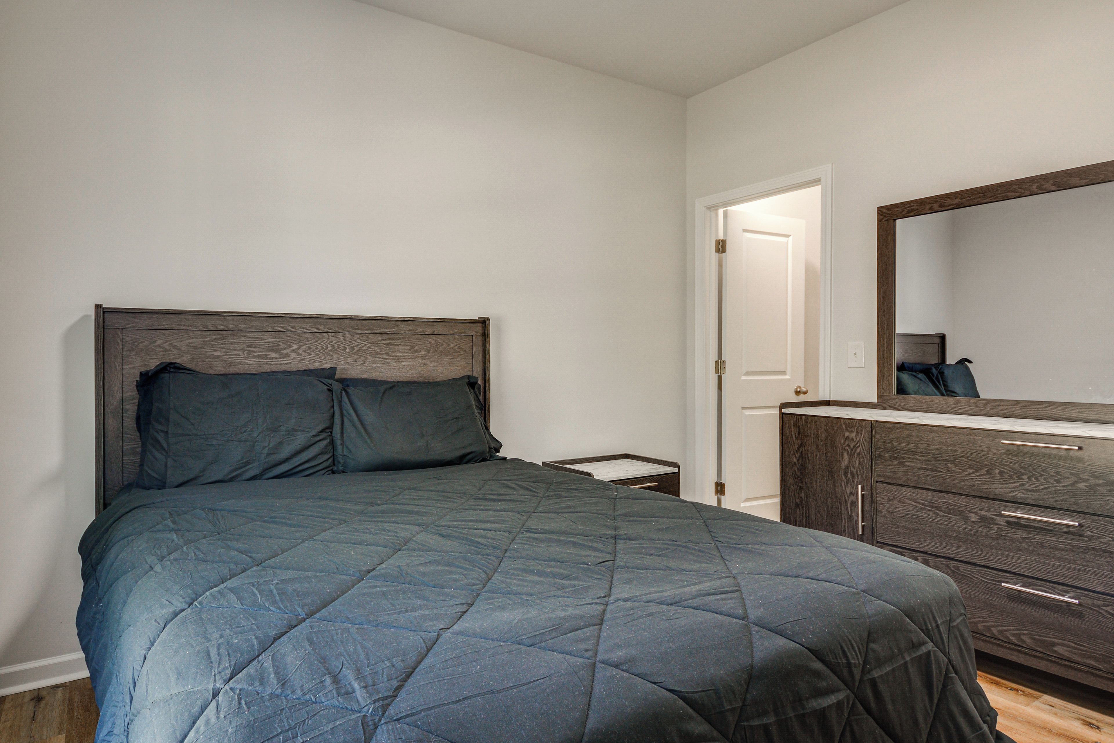Un dormitorio con una cama, un aparador y un espejo.